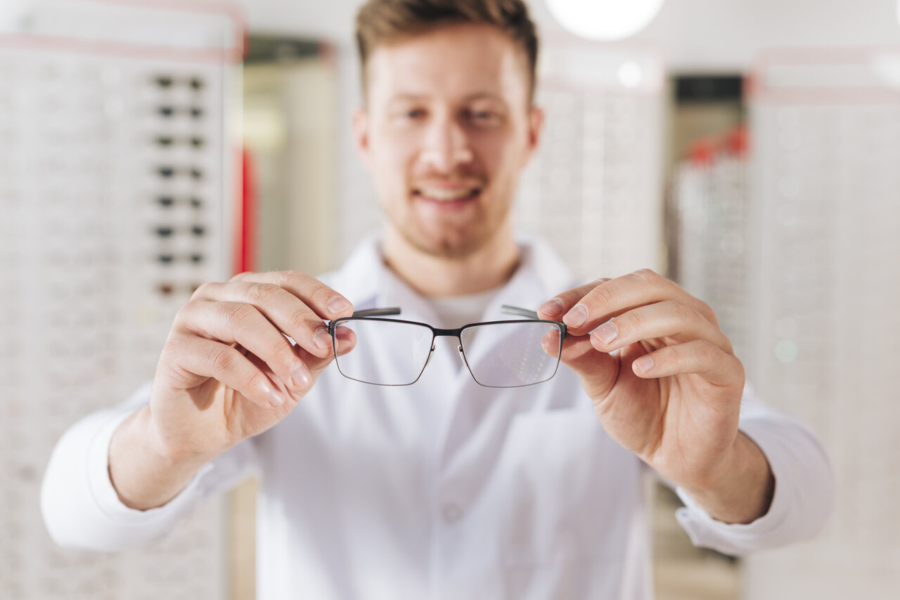 Homem branco com óculos na mão reforçando a independência desse acessório com a realização da cirurgia refrativa.